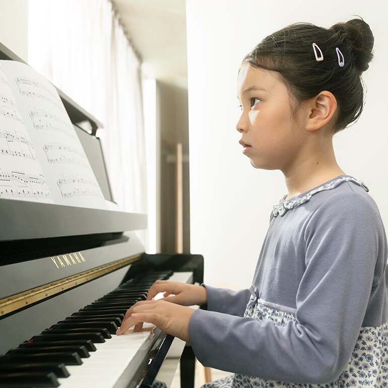 A child enjoys playing the upright piano B series
