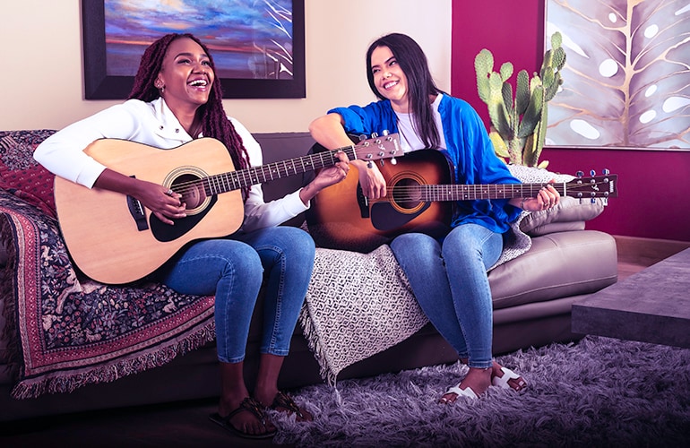 Two women playing the Yamaha F310 - acoustic guitar for beginners
