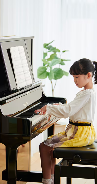 Young girl at her Yamaha upright piano